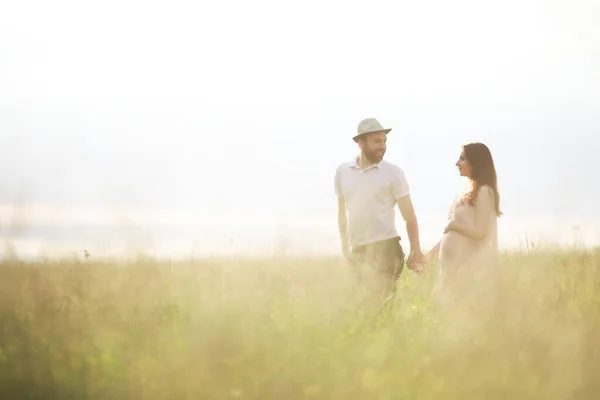 Paar man en zwanger meisje in het veld — Stockfoto