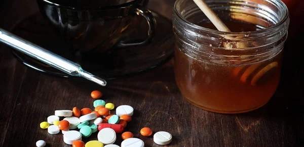 Drogas y pastillas en una mesa de madera. Varios medios para prevenir el frío — Foto de Stock