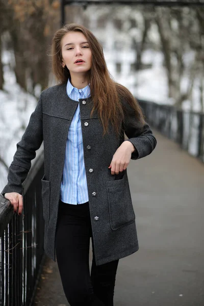 Mladá dospělá žena v plášti na ulici — Stock fotografie