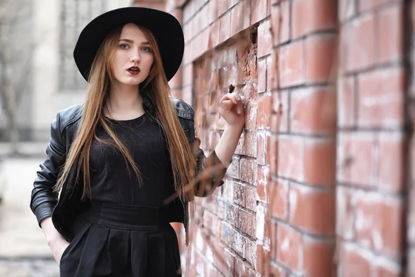 Menina bonita nova em um chapéu e com uma maquilagem escura do lado de fora. G — Fotografia de Stock