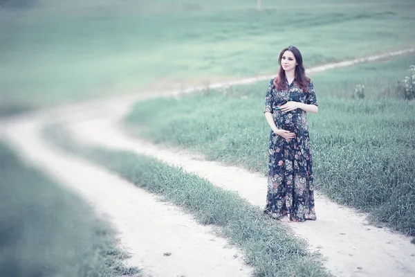 Pregnant girl in a dress in nature — Stock Photo, Image