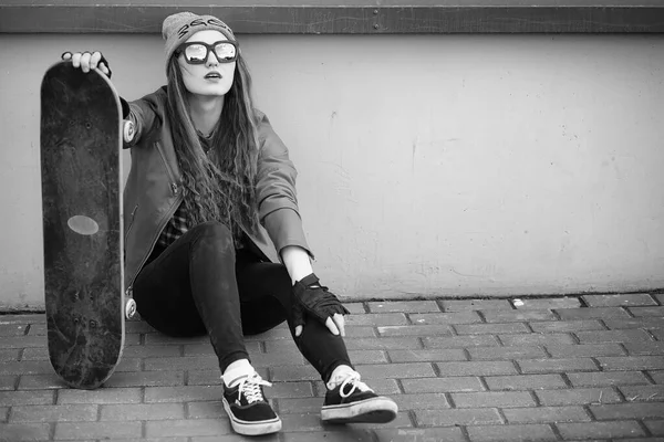 一个年轻的时髦女孩正在骑滑板。女孩女朋友 f — 图库照片