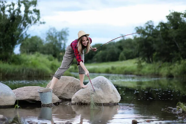 Menina junto ao rio com uma vara de pesca — Fotografia de Stock