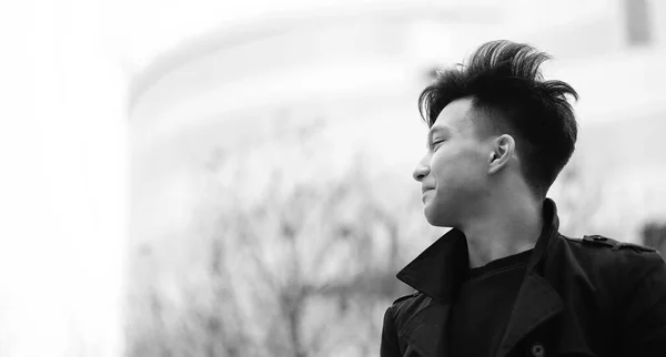 Black White photo of Asian young man outdoors posing