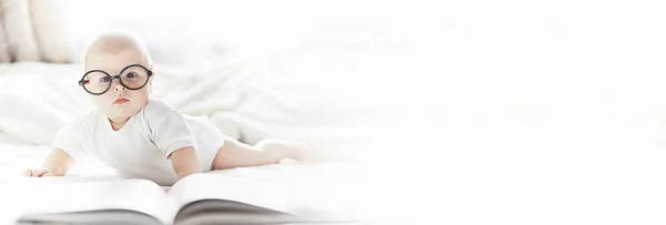 Yeni doğmuş bir bebek yumuşak bir yatakta gözlüklerle yatıyor.. — Stok fotoğraf
