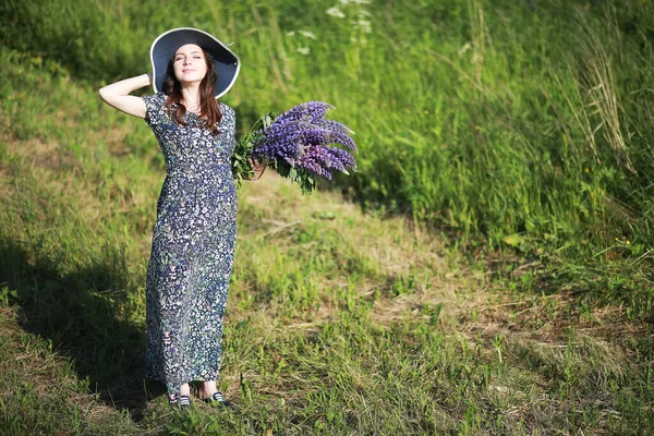 Ragazza incinta in un campo con lupini — Foto Stock