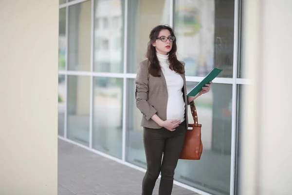 Беременная женщина разговаривает по телефону на улице — стоковое фото