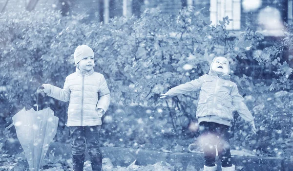 Crianças caminham no parque primeira neve — Fotografia de Stock