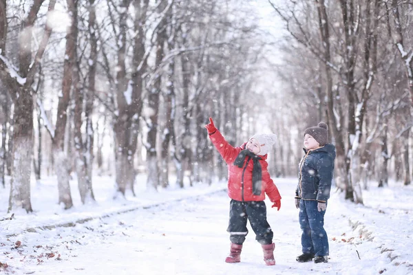 Crianças caminham no parque primeira neve — Fotografia de Stock