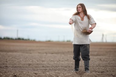 Genç bir köylü tahıl alanıyla sows