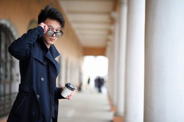 Asya genç adam sokakta bir ceket