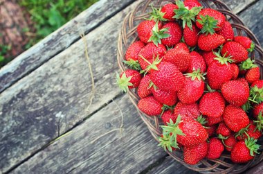 Hasır plaka ahşap arka plan üzerinde çilek