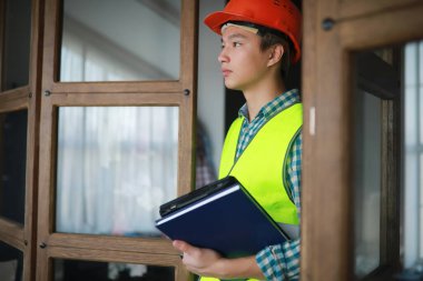 Kask ve inşaat koruyucu yelek Asyalı adam