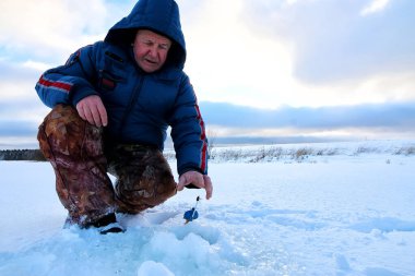 Göl kenarında balıkçı kış