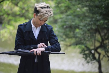 Bahar yağmurlu hava ve bir şemsiye ile genç bir adam