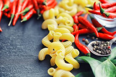 Taş zeminde pişmemiş makarna. Baharat ve baharatlarla