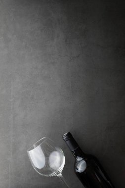 Şarap kadehi ve siyah şarap şişesi. Ceviz peyniri ve domates.