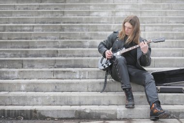 Basamaklarda rock gitaristi. Bir bas gitar bir müzisyenle bir 
