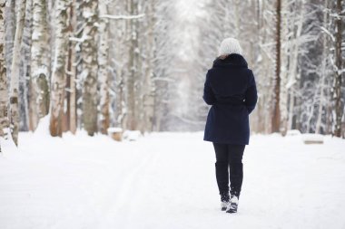 Genç bir kız bir kış parkta bir yürüyüş. Noel tatili t