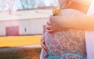 Hamile kız parkta bir yürüyüş. CI karnından kızla