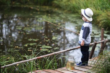 Kampanyada bir çocuk gölette balık yakalar.