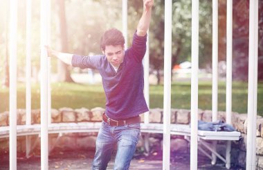 Genç bir adam öğle yemeği zamanında parkta yürür. Bir adam yürüyüşe çıktı. 