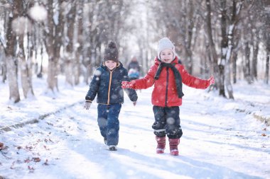Çocuklar parkta ilk kar yürümek