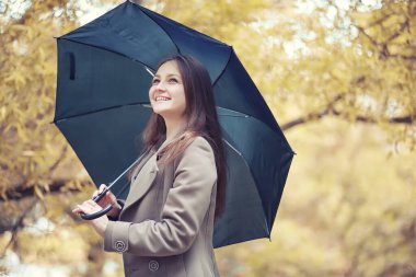 Sonbahar yağmurlu hava ve bir şemsiye ile genç bir adam