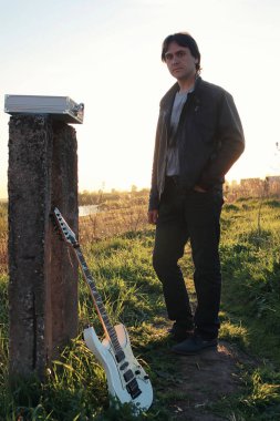 Adam açık havada ve endüstriyel yatay olarak bir elektro gitar ile