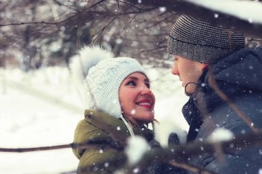 Genç bir çift kış parkında yürüyor.