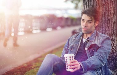 Genç bir adam öğle yemeği zamanında parkta yürür. Bir adam yürüyüşe çıktı. 