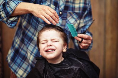 Küçük bir çocuk kuaförde kesilmiş. 