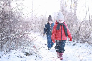 Çocuklar parkta ilk kar yürümek