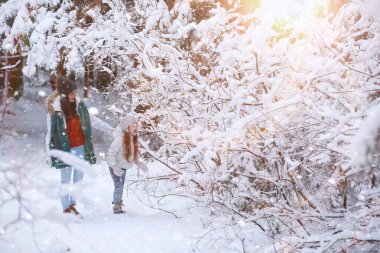 Genç bir aile yürüyüşe çıktı. Anne ve kızı şarapla yürüyorlar.