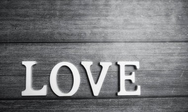 ahşap arka plan üzerinde beyaz tahta harflerle yapılan kelime aşk