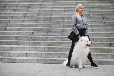 Güzel bir köpekle yürüyüşe çıkmış güzel bir kız. 