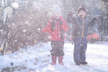 Çocuklar parkta ilk kar yürümek