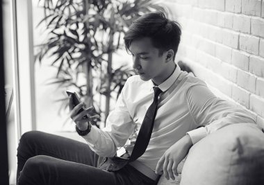 Genç Asyalı işadamı bir kafede bir ortak için bekliyor. Bu