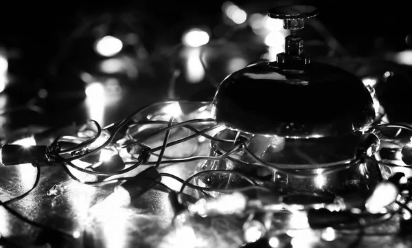 Recepcji dzwonek na stole i błyszczący garland tło — Zdjęcie stockowe