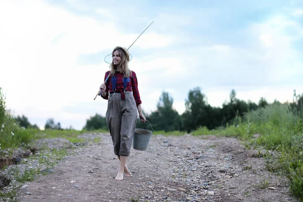 Chica junto al río con una caña de pescar — Foto de Stock