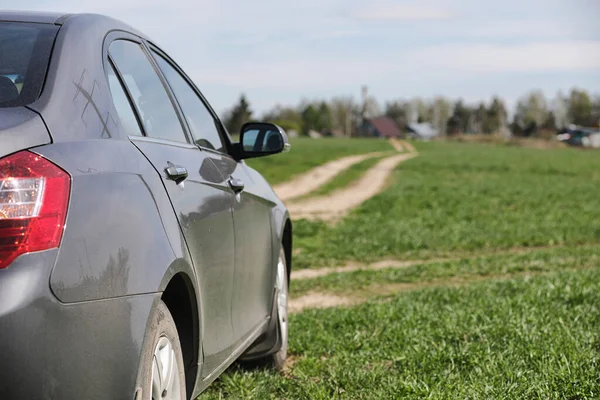 O carro está estacionado no campo. O carro está dirigindo ao longo do rur — Fotografia de Stock