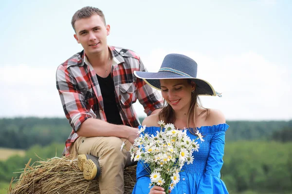 Par i kärlek i ett fält vid solnedgången — Stockfoto