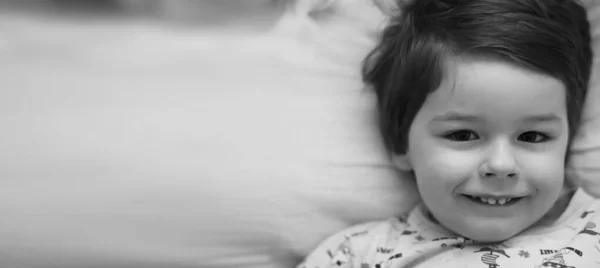 Foto in bianco e nero ritratto di un bambino sdraiato su un pillo — Foto Stock