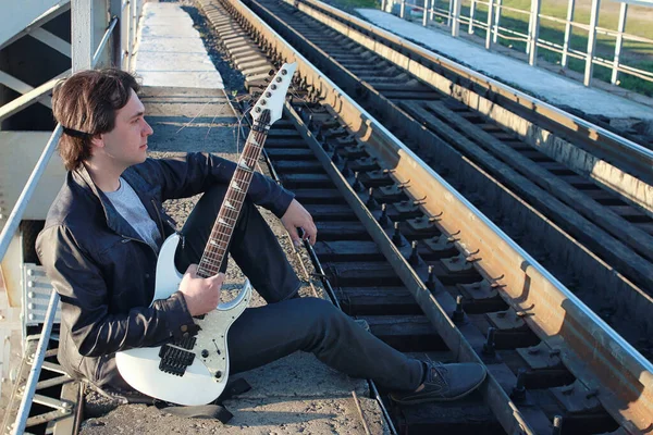 Man with an electric guitar in the industrial landscape outdoors — Stock Photo, Image