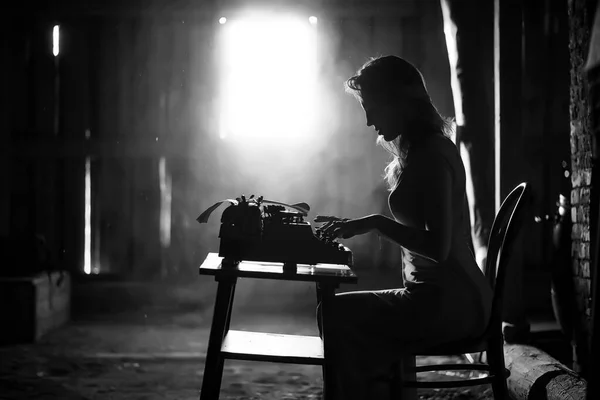 Ein Mädchen druckt auf einer alten Schreibmaschine — Stockfoto