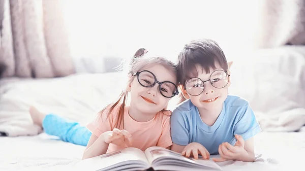 Kinder liegen auf dem Bett neben dem Neugeborenen, kleine Schwester. — Stockfoto