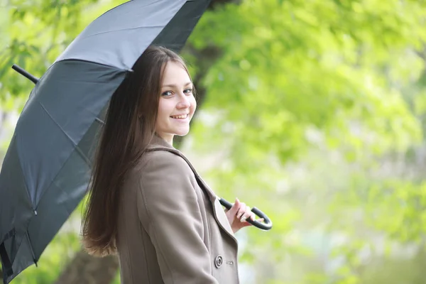 Young girl in a coat in a spring park — Stock Photo, Image