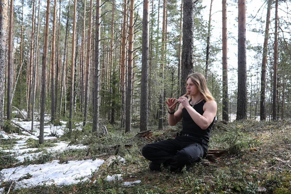 Um músico com uma ferramenta na natureza. Um homem está tocando uma flauta em um — Fotografia de Stock