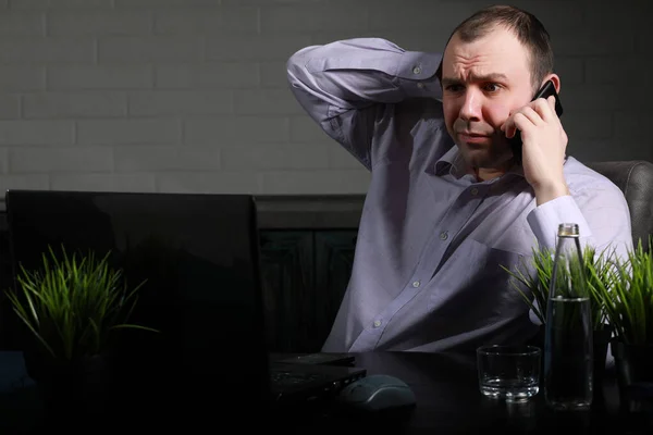 Homme assis à table et travaillant sur un ordinateur portable — Photo