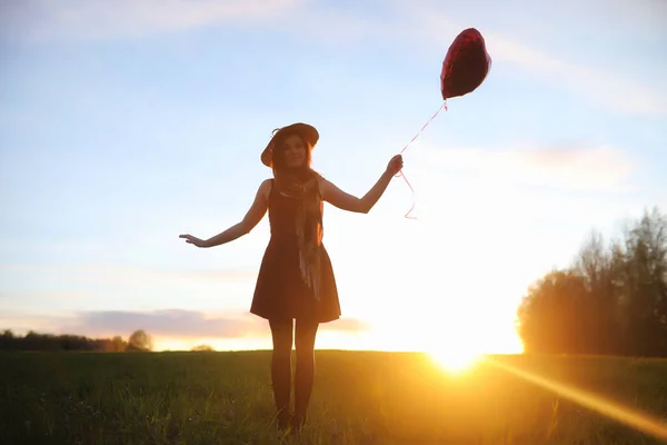 Una ragazza con un cappello mentre passeggia nel parco. Una ragazza con un cesto a piedi — Foto Stock